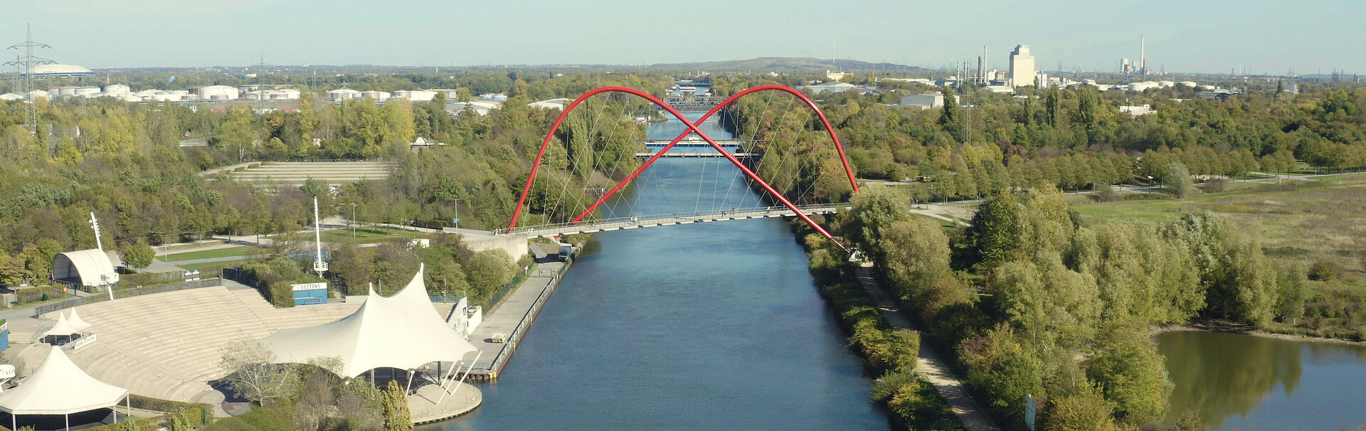 Das Bild zeigt die rote Doppelbogenbrücke, die sich über den Rhein-Herne-Kanal spannt.