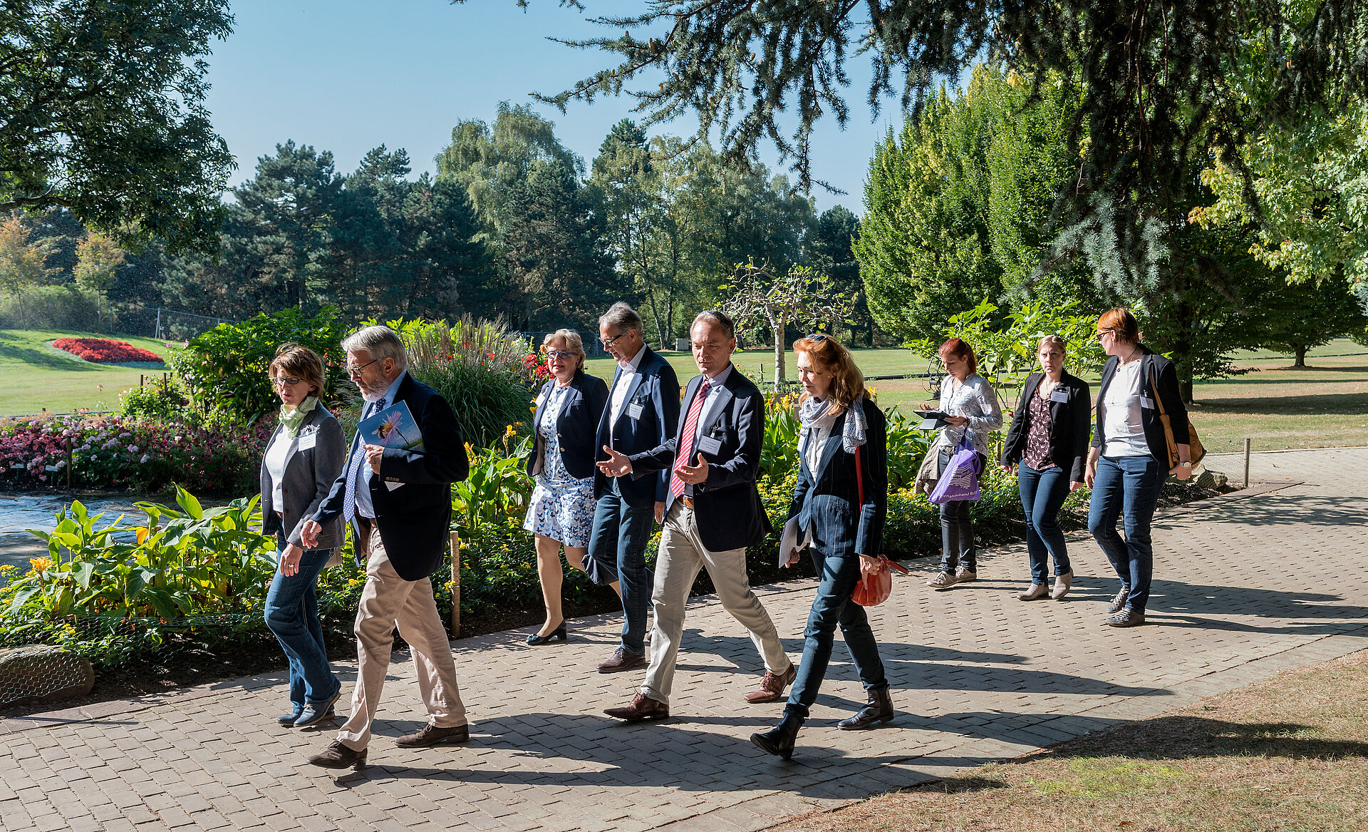 Das Bild zeigt eine Menschengruppe, die einen Weg im Westfalenpark Dortmund entlang geht.