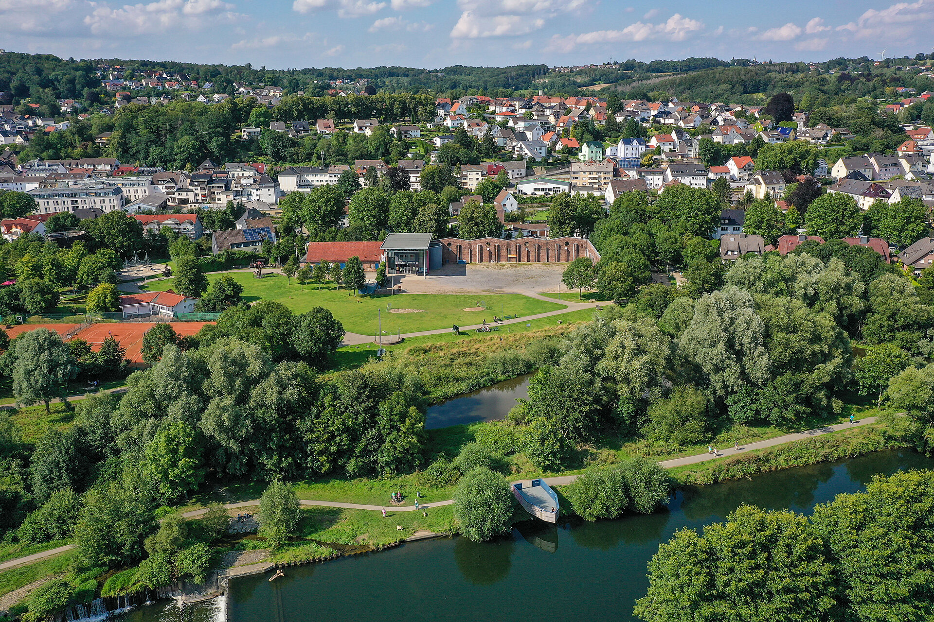 Vogelperspektivischen Blick auf den Wohnort und im Vordergrund grüne Wiesen und Bäume am Ufer der Ruhr