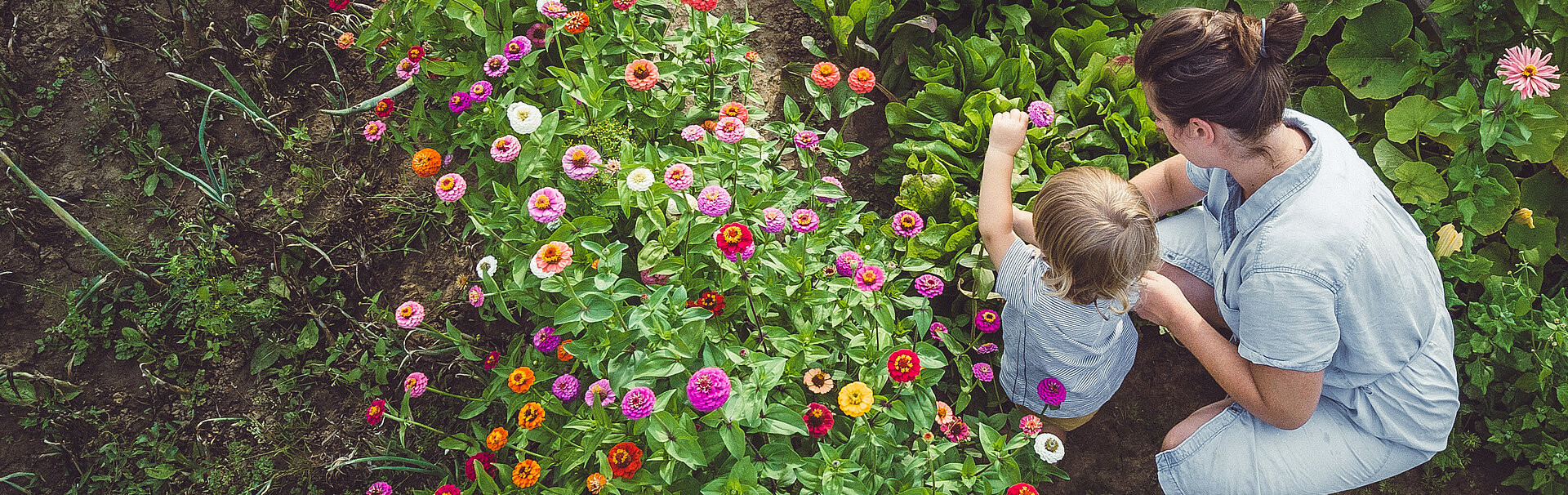 Frau mit Kind im Garten mit Blumen