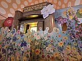 Natur und Judentum Das Foto zeigt im Vordergrund ein buntes Blumenmeer und im Hintergrund ist der Toraschrein der Alten Synagoge zu sehen.