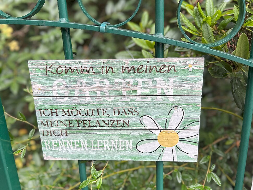 Holzschild am Torgatter hängend: "herzlich willkommen" 