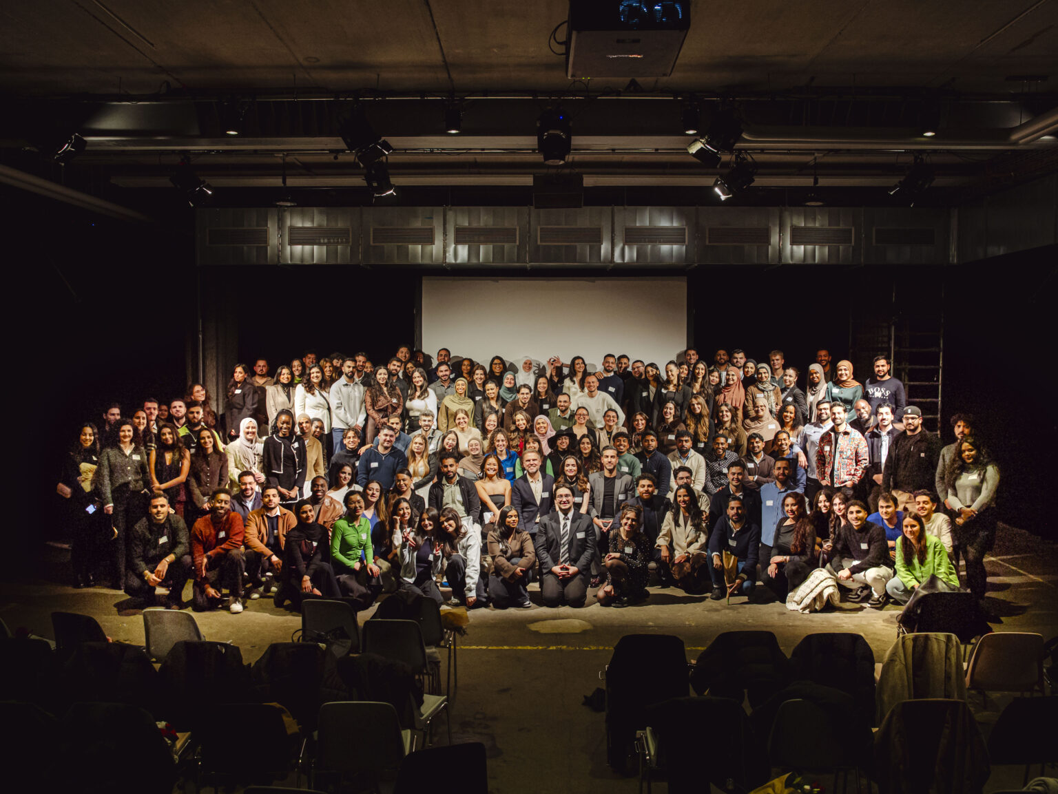 InteGREATer_Gruppenfoto Eine große Gruppe von Menschen auf einer Bühne.