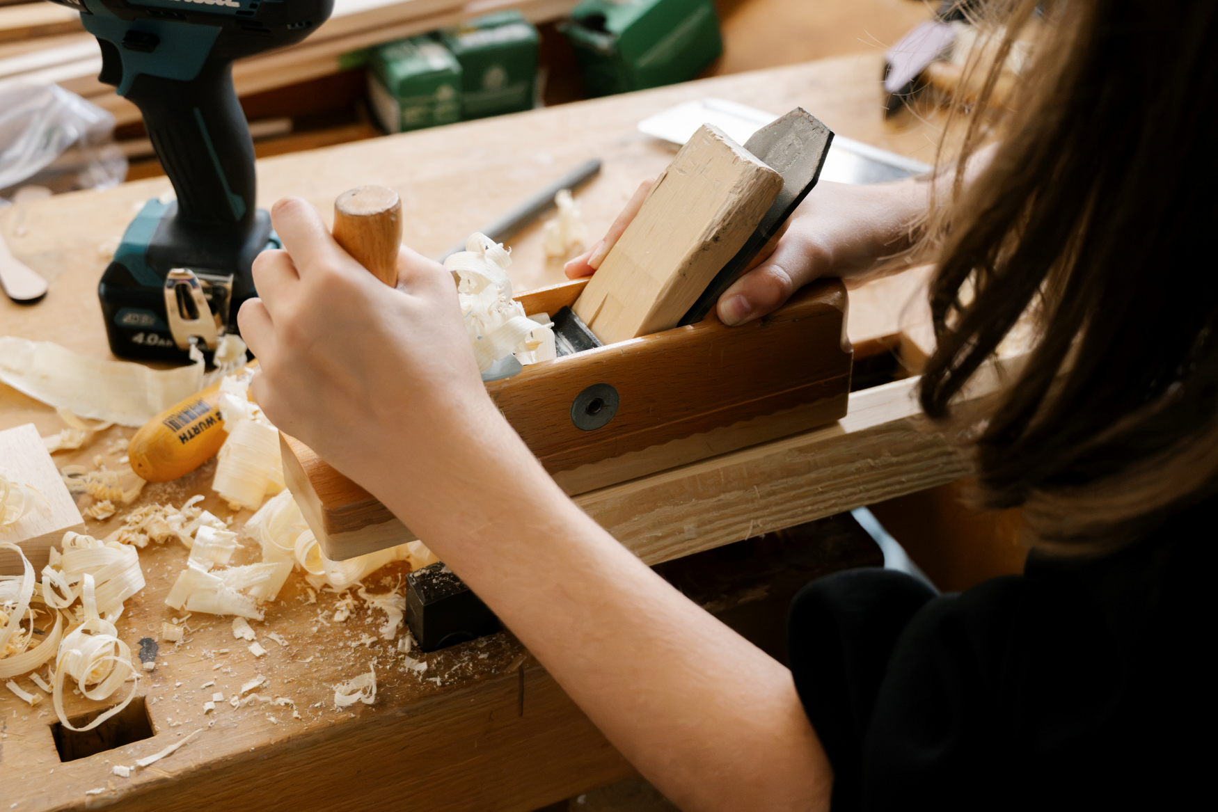 Handwerkskammer Dortmund Ein Mädchen, das an einer Werkbank steht und einen Holzhobel in der Hand hält