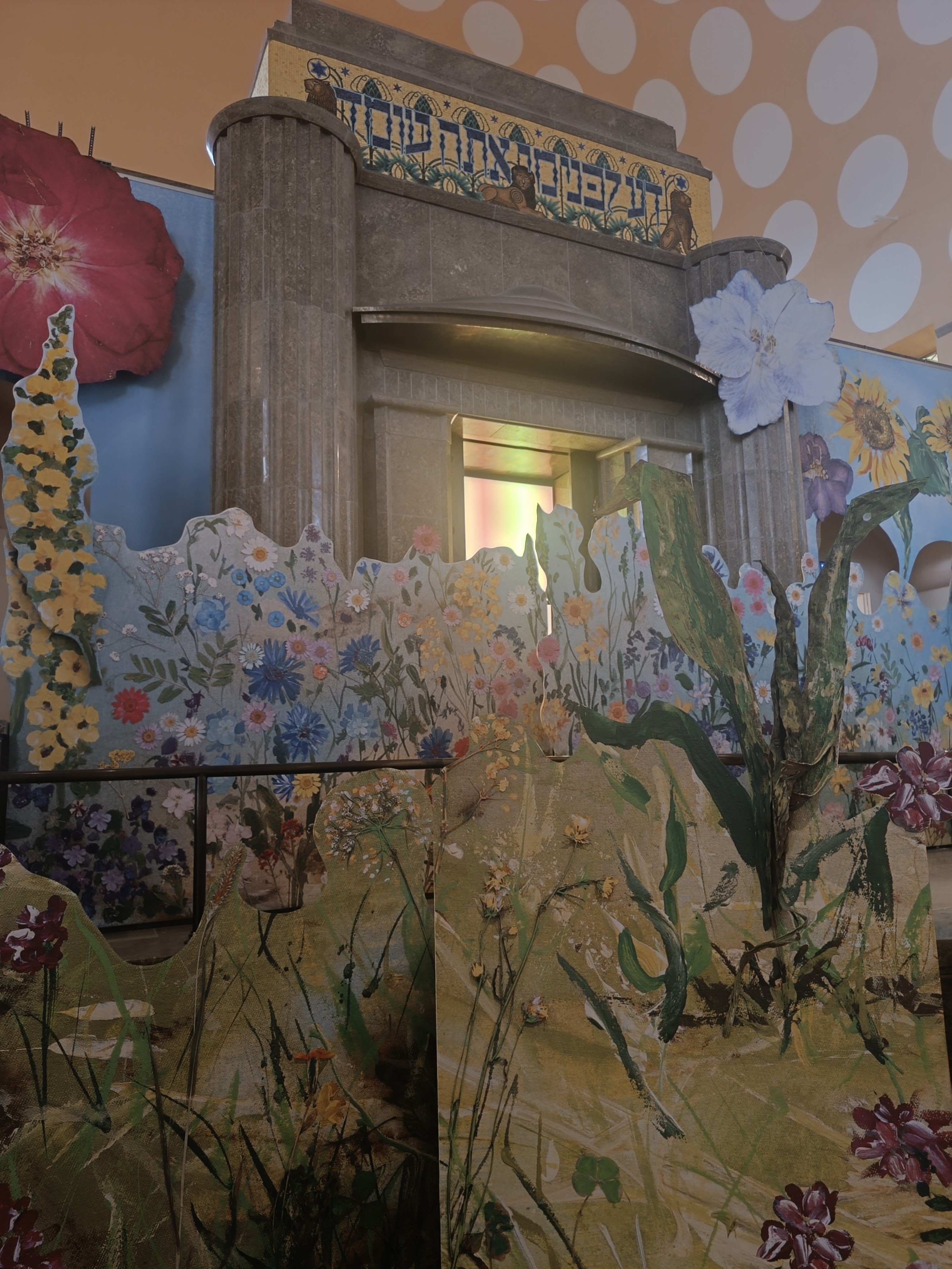 Toraschrein_Alte Synagoge Essen_Sandberg 2026 Das Foto zeigt im Vordergrund ein buntes Blumenmeer und im Hintergrund ist der Toraschrein der Alten Synagoge zu sehen.
