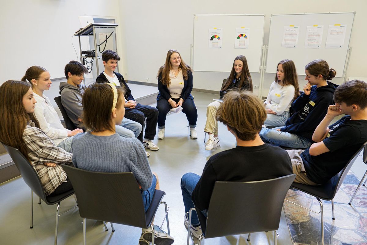 Schulworkshop_youmocracy e.V. Schüler*innen sitzen im Stuhlkreis und diskutieren.