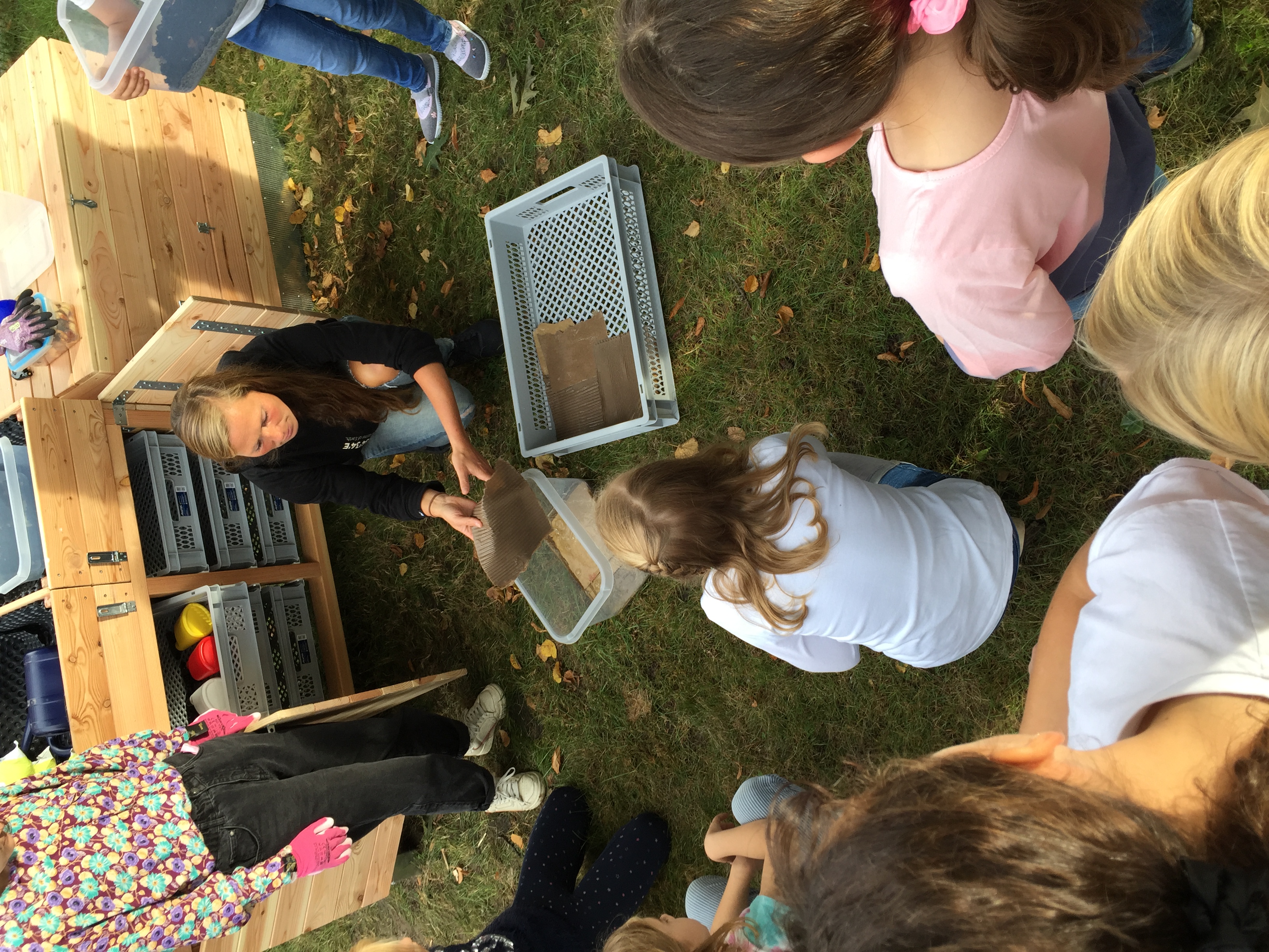 Janina erklärt den Kindern den Kompostwurm direkt vor der Wurmkiste.