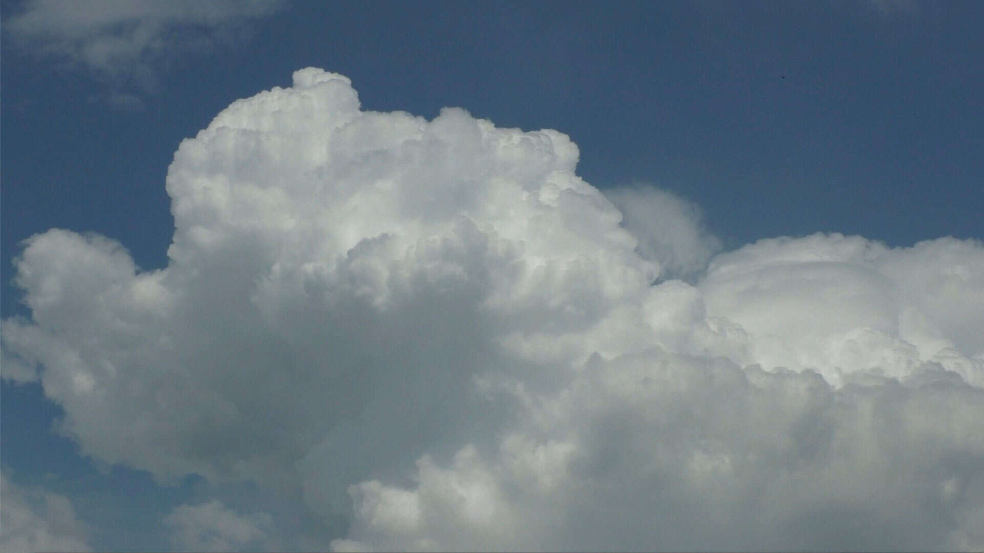 wolkenbildung (cumulus-wolkenbergen) vor blauem himmel