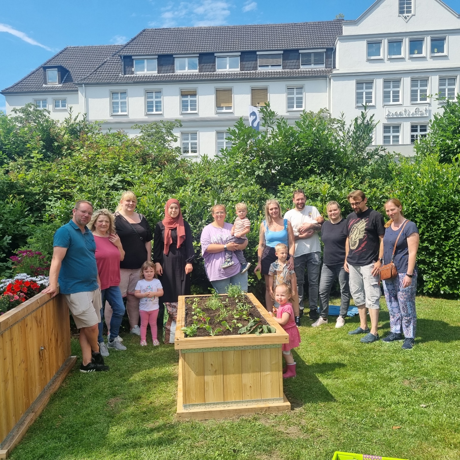 Interkultureller Hochbeetgarten Gladbeck Das Foto zeigt Kinder und Eltern eines Kindergartens an ihrem Hochbeet