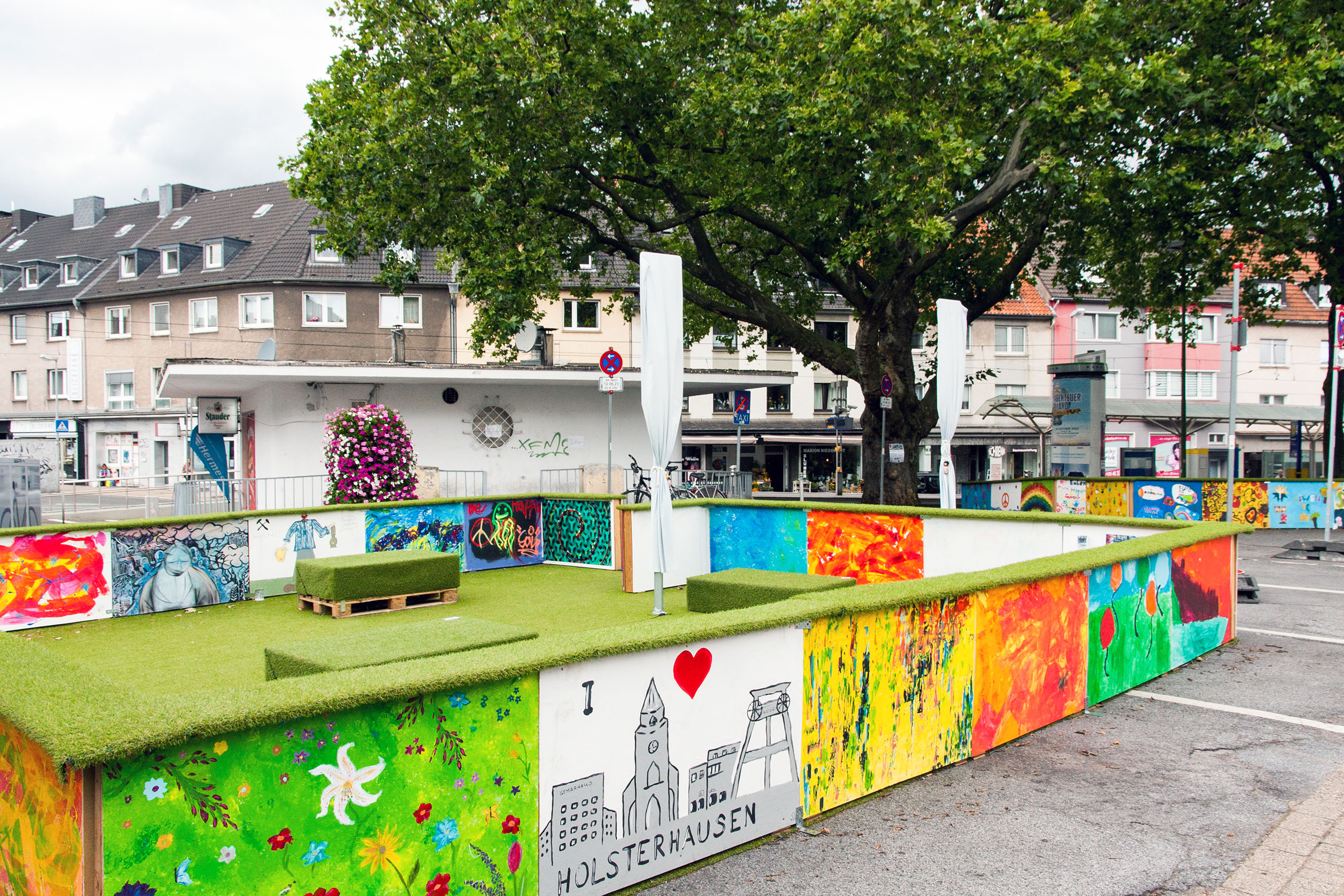 Das Foto zeigt den Gemarkenplatz in der Stadt Essen, auf dem eine farbenfrohe Installation aufgebaut wurde. 