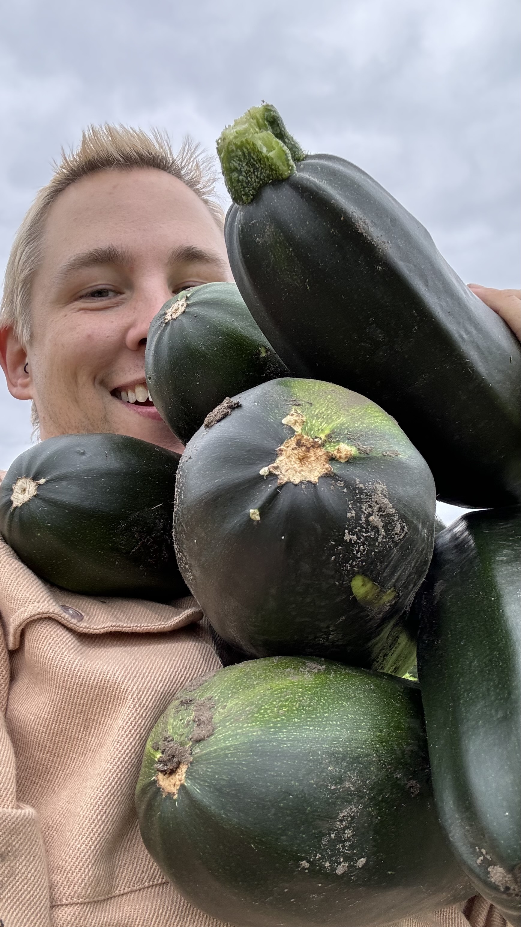 Mietgarten Düsseldorf Eine Gärtnerin präsentiert ihre Zucchiniernte
