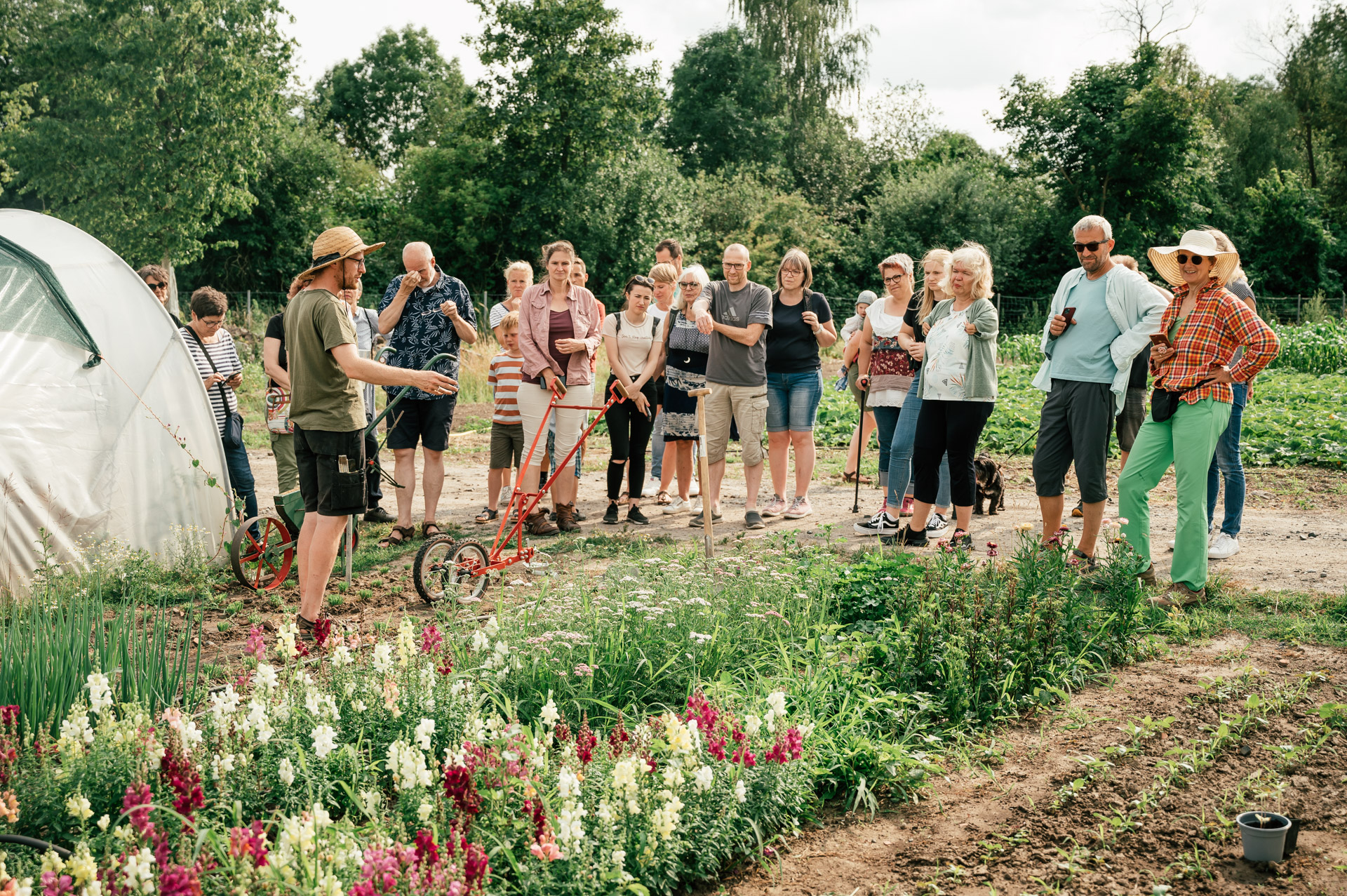 Gärtnerei Stadtgemüse-Solawi Gärtner Laurin Liekenbrock erklärt seine Anbauweise einer Gruppe von Mitgliedern der solidarischen Landwirtschaft.
