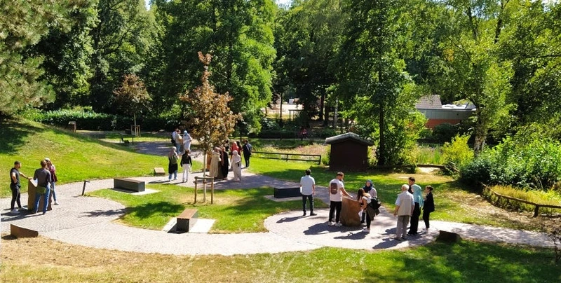Interreligiöser Rundgang durch den Garten Menschen beim Gespräch im Garten der Religionen