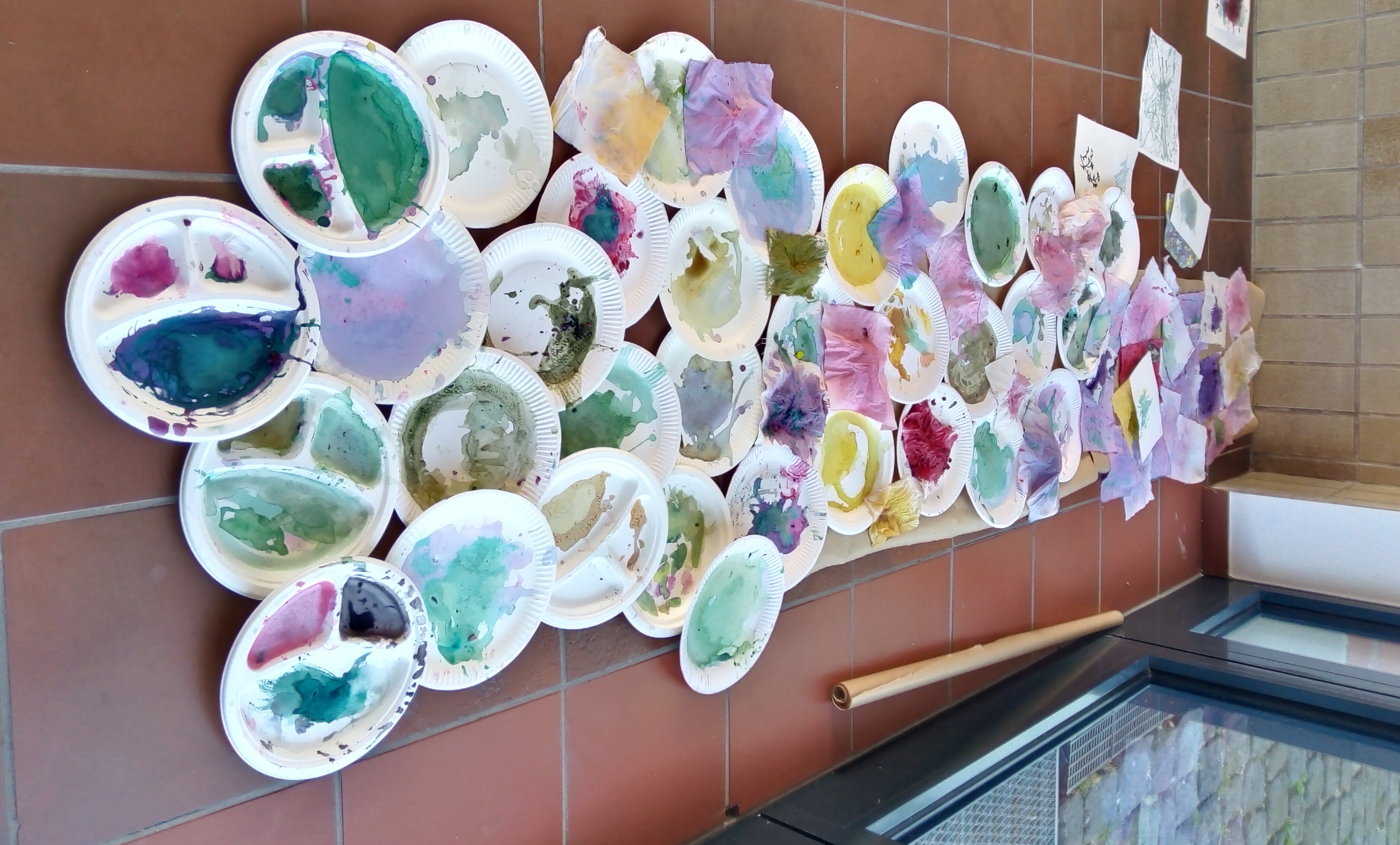 Färberworkshop 2024 Schirrhof_Kamp-Lintfort Zahlreiche bunte Unterlagen zeigen die Farbpalette aus einem Färberworkshop mit Pflanzenfarbe