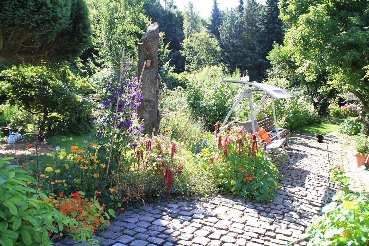 Ruheplatz am blütenumsäumten Gartenweg