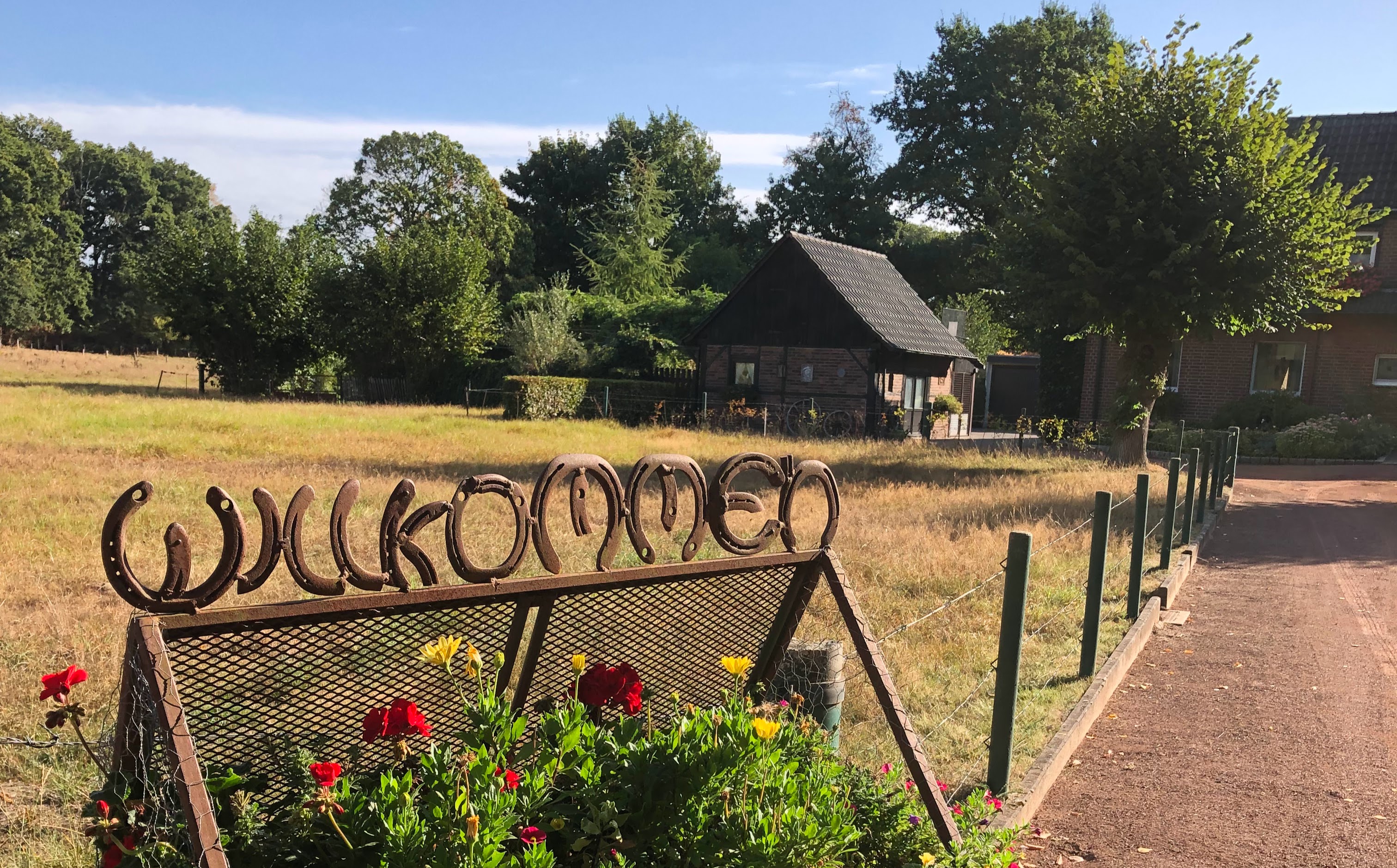 Landleben op de Kuhle, Dorsten, L.Demmer, 2025 Willkommensschild aus Hufeisen mit Blick auf das Fachwerkhäuschen.