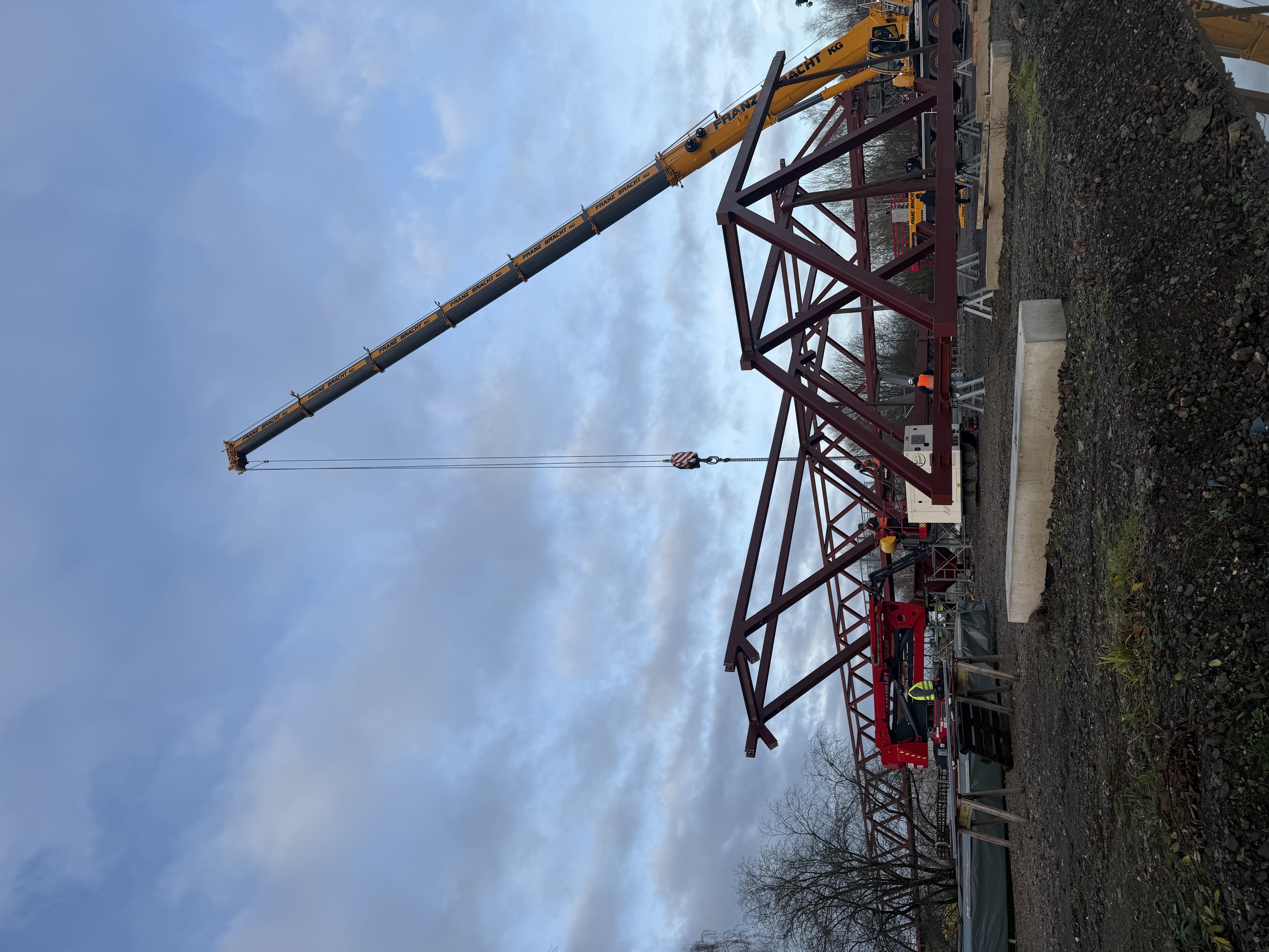 Ein Baukran hebt ein Stahlgerüstteil