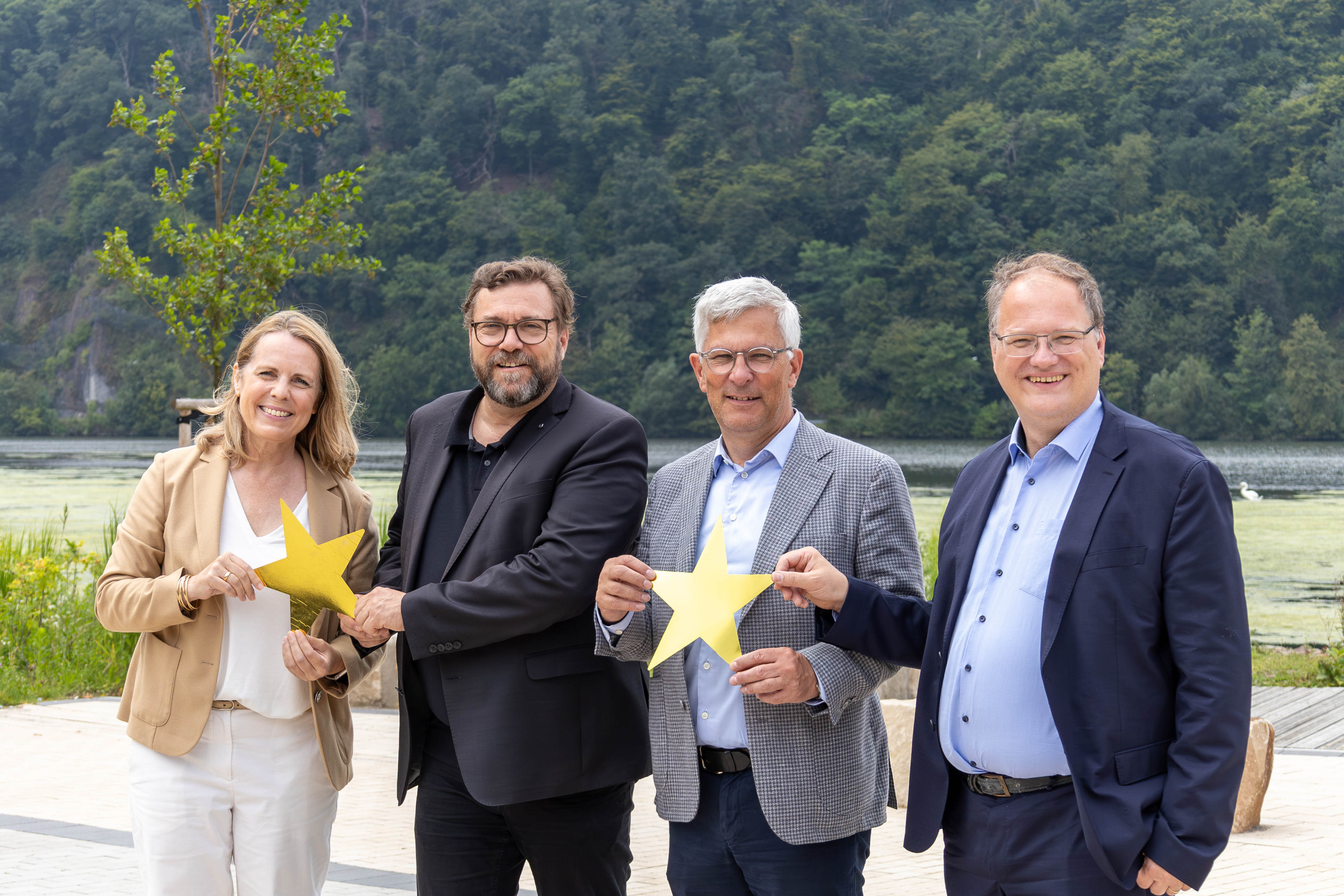 Vier Personen stehen mit dem Rücken zum Hengsteysee und halten einen Stern in der Hand
