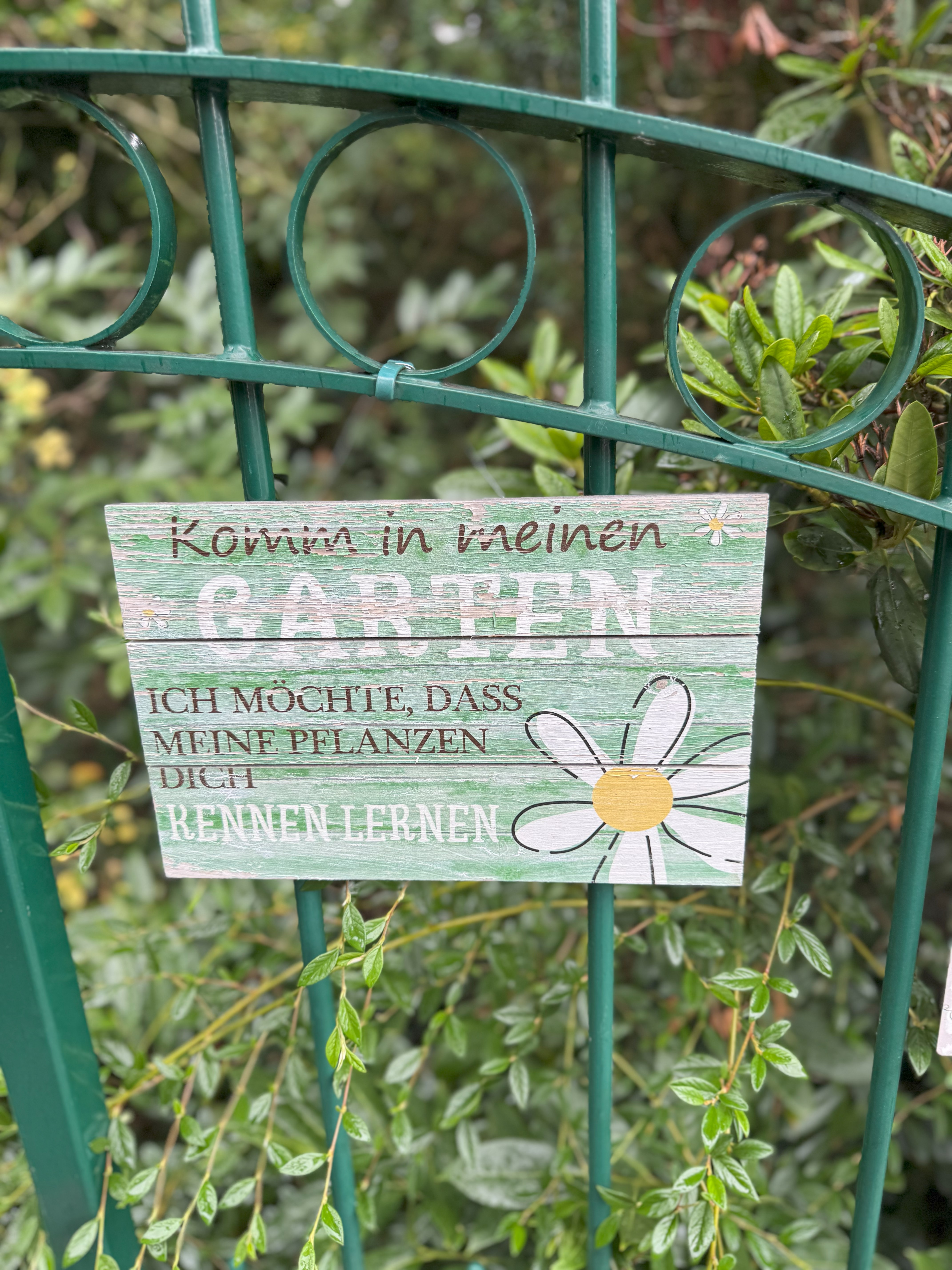 Holzschild am Torgatter hängend: "herzlich willkommen" 