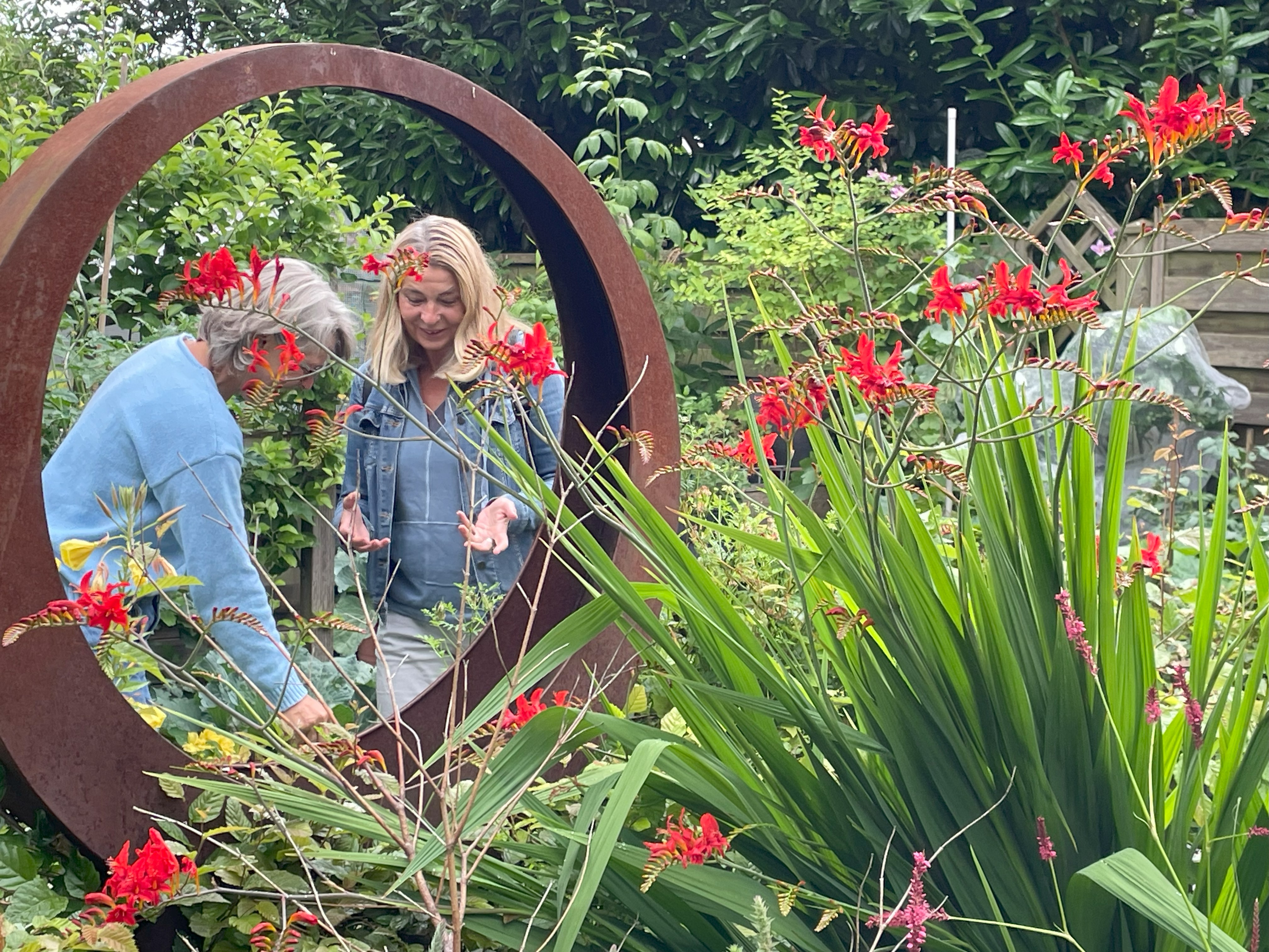Zwei Frauen im Gespräch in einem Garten