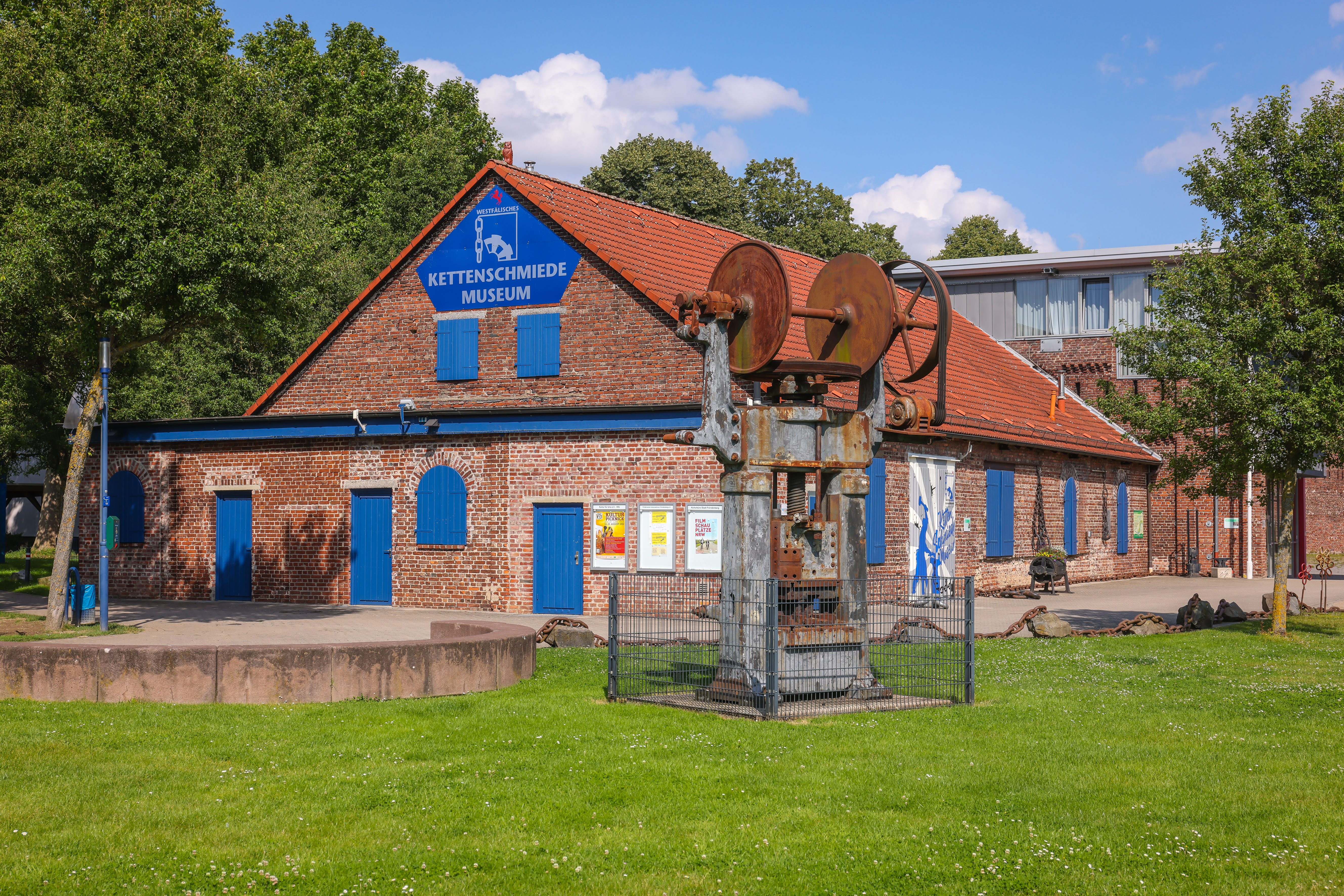 Frontalblick auf das Backsteinhaus mit blauen Türen und Fenstern, das Kettenschmiedemuseum