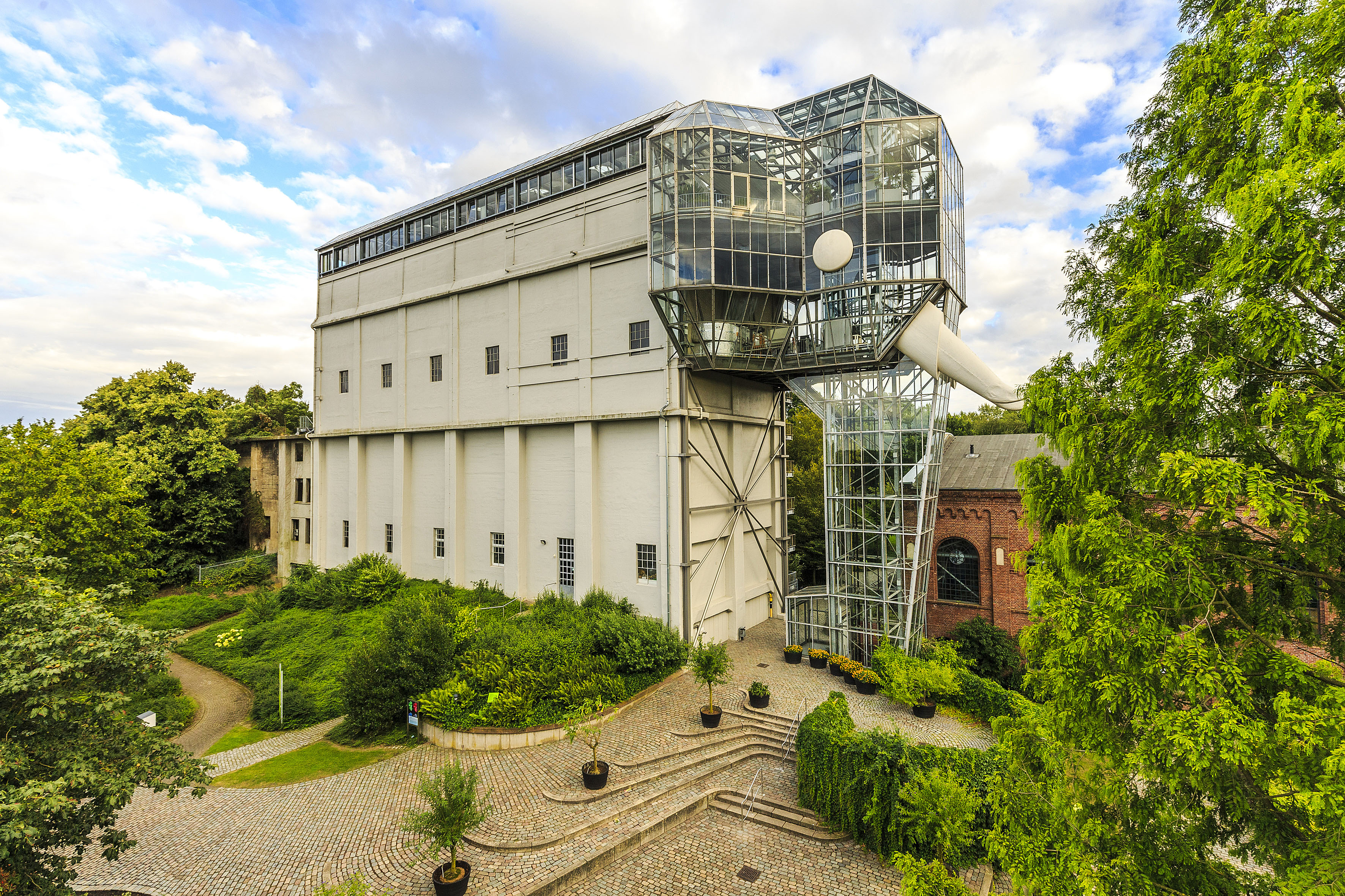 Hohes beiges Gebäude, rechts verziert mit Glaswänden