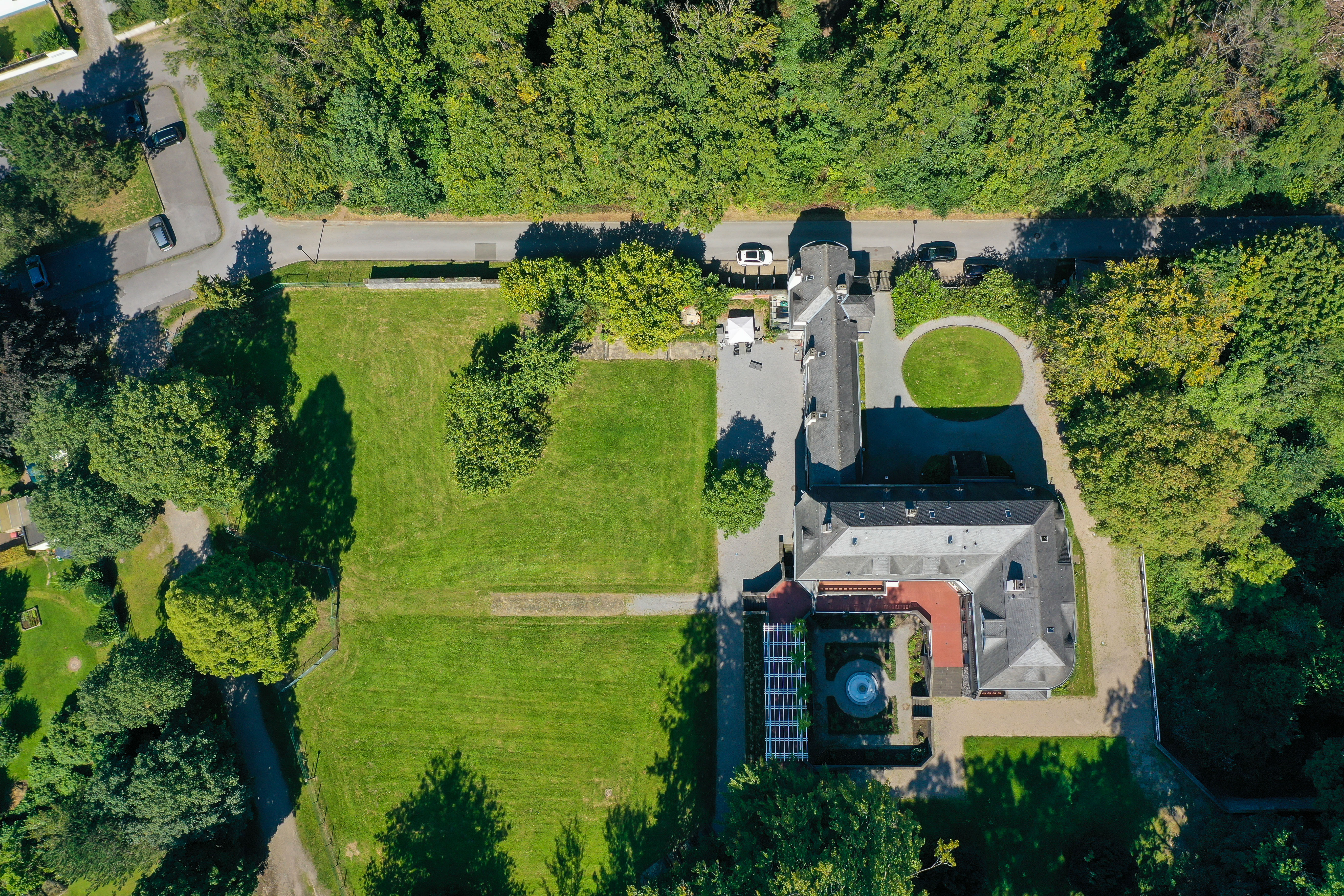 Drohnenansicht auf das Haus und die grüne Gartenanlage der Villa Hohenhof